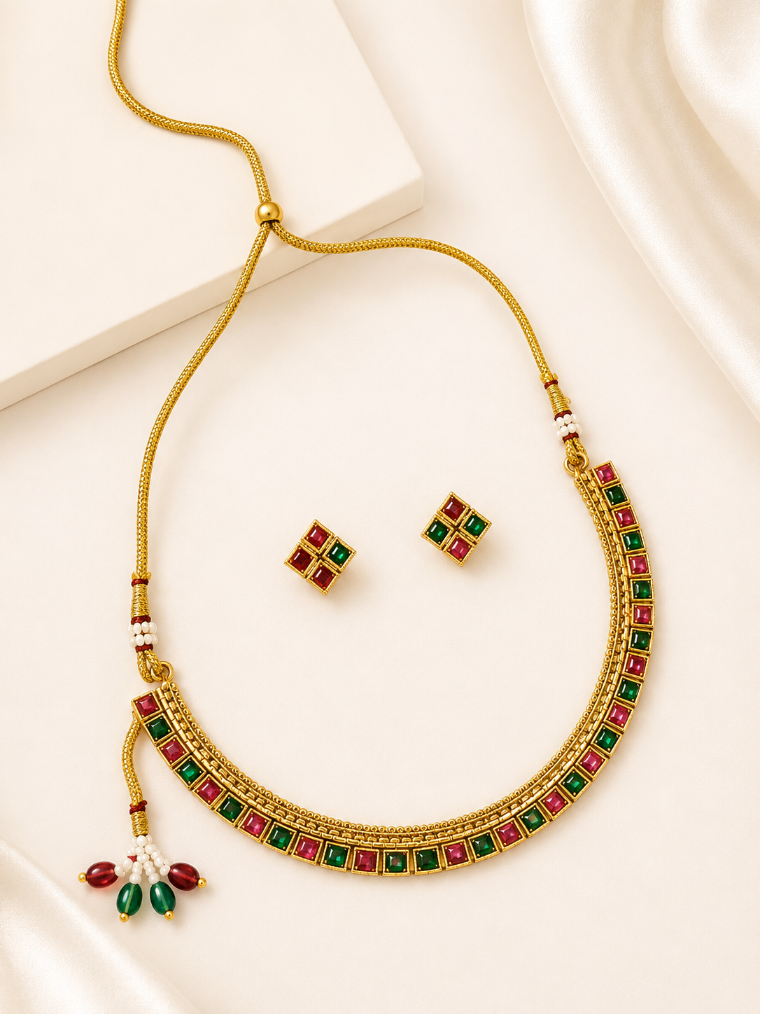 Antique gold-tone imitation Kundan choker necklace set with ruby-red and emerald green square stone inlays and matching stud earrings