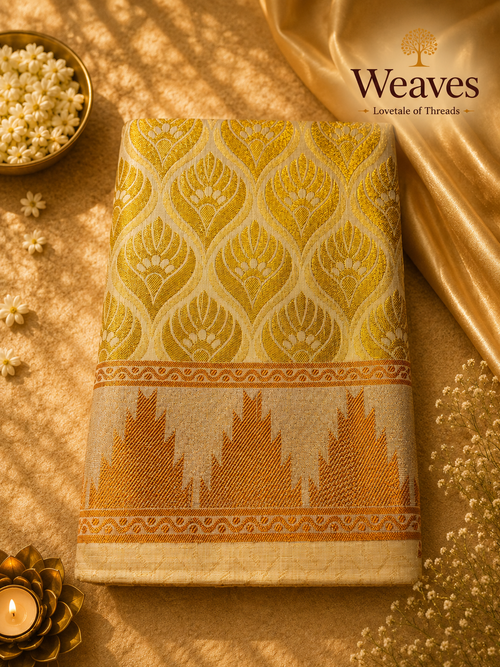 Cream and gold tissue saree folded showing gold zari leaf weave and temple border