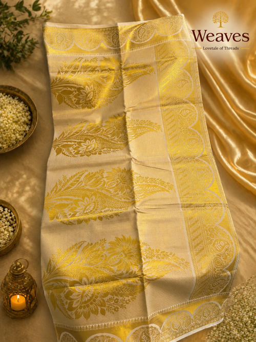 Cream tissue saree unfolded showing full body gold botanical zari weave and scalloped paisley border pallu