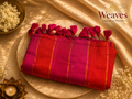 Red and magenta ombre mul cotton saree folded showing gold zari stripes and matching magenta tassel pallu fringe