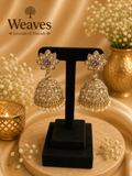 Gold Polki Kundan Jhumka Earrings with amethyst purple centre floral stud and pearl drops on black earring stand