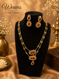 Ruby floral necklace and matching earrings jewellery set on a black display bust