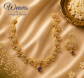 Gold-tone floral necklace and matching earrings with clear, blush, and purple accent stones