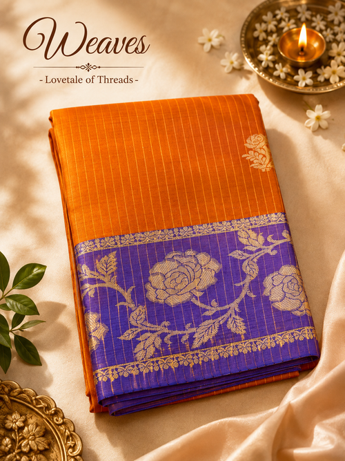 Folded copper orange soft silk saree with repeating gold-toned woven motifs