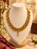 Gold-tone peacock-inspired necklace with deep pink stone accents and a centre drop pendant