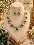 Gold-tone green stone necklace and matching earrings set with clear accent stones