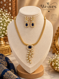 Gold-tone leaf pendant necklace and matching earrings set with purple centre stones