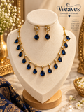 Gold-tone necklace set with sapphire blue pear-cut teardrop stones and matching earrings