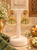 Antique gold peacock jhumka earrings with green and white stones and pearl drop fringe