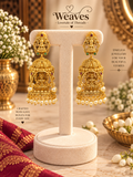 Antique gold nagas temple jhumka earrings with Lakshmi motifs, red and green stones, and pearl drops