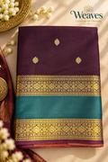 Folded wine katan silk saree with gold buttas, teal band, and gold floral borders