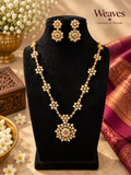 Imitation floral gold-tone necklace and matching earrings with clear stone-style accents and statement pendant