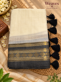 Cream mul cotton saree with charcoal-black and gold-toned geometric border and black tassels