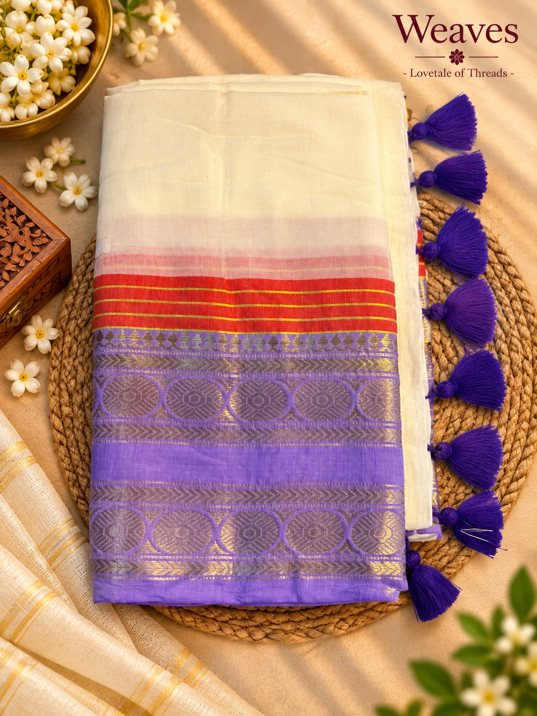 Off-white mul cotton saree with red and purple border, gold-toned pattern detailing, and purple tassels